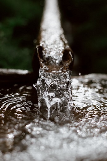 Water gushing out of a pipe. Photo by Eberhard Grossgasteiger from photo website Pexels.