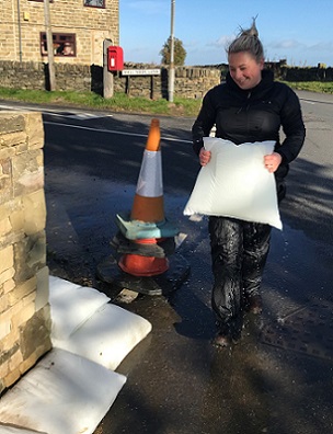 Lucy Bailey from Environmental Defence Systems Ltd building an anti-flood barrier from FloodSax alternative sandbags