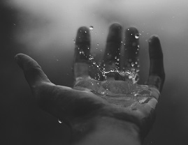 Rain hitting a hand. Photo by Geetanjal Khanna on Unsplash.