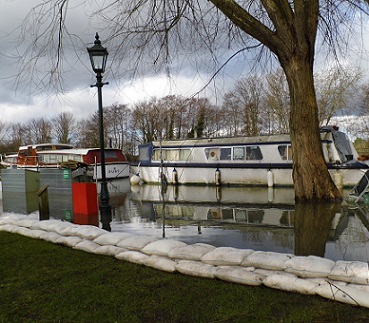 A wall of FloodSax sandless sandbags stopping water from overflowing this river bank