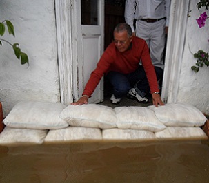 A wall of FloodSax alternative sandbags keeping filthy floodwater out of a home