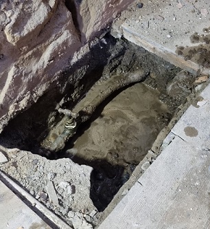 The leaking stop tap and lead pipe hidden beneath floorboards at a cottage in Huddersfield, West Yorkshire